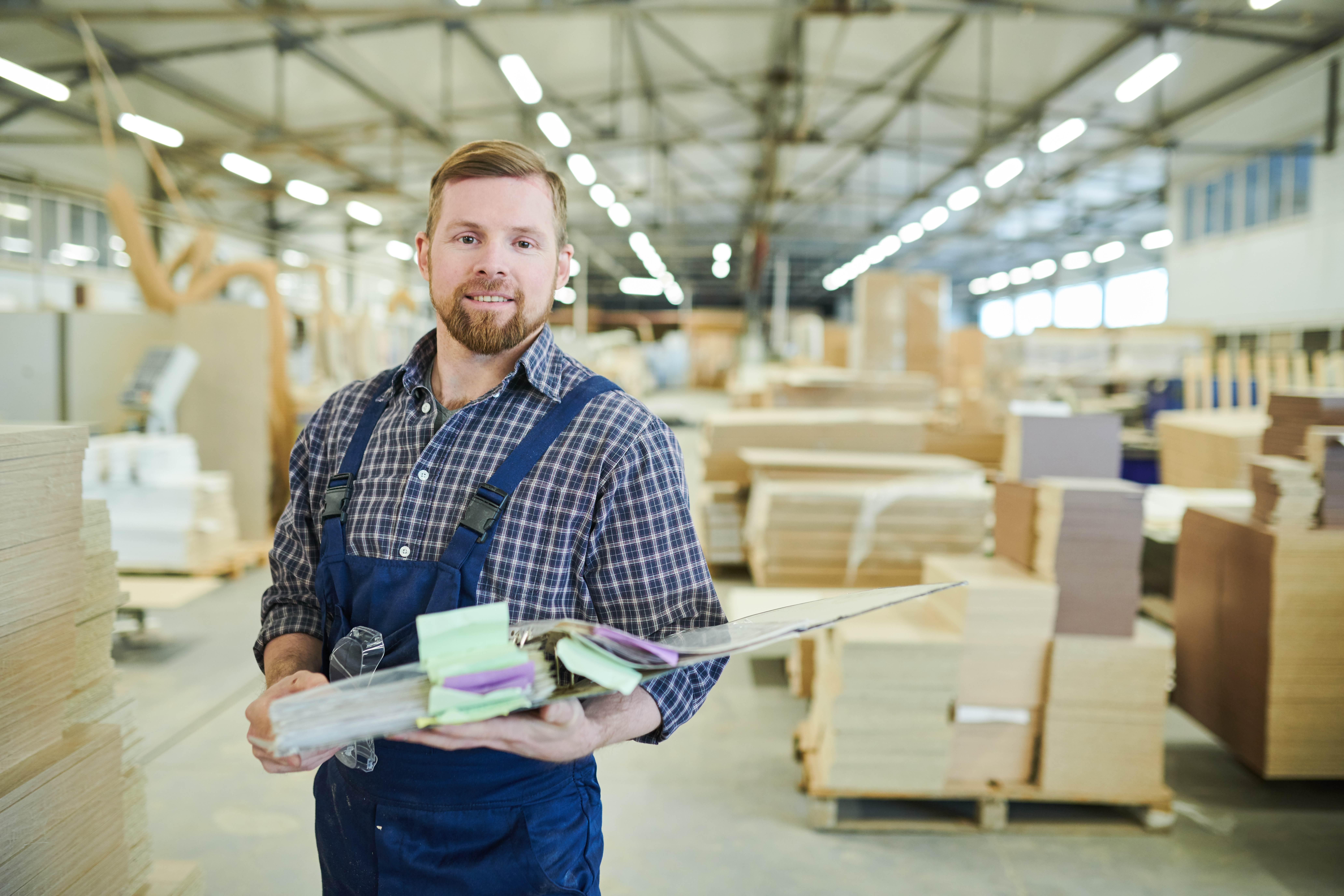 Smiling factory inspector holding folder